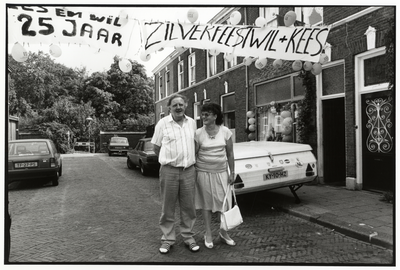 108014 Portret van Wil en Kees bij hun huis Takstraat 45 te Utrecht, tijdens de viering van hun zilveren bruiloft.